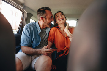Loving couple having fun in the backseat of a car