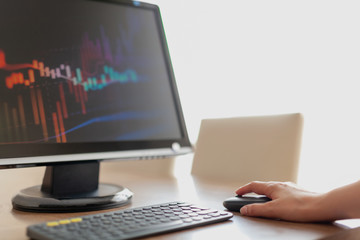 Financial Data Concept:Woman hand pressing mouse to look at financial data.Financial and business graphs, Finance concept on led screen.