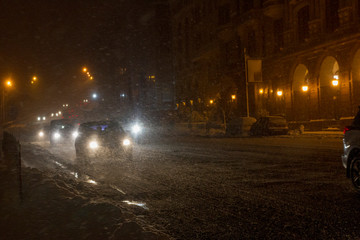 Fototapeta na wymiar Winter snow storm.Night traffic jam . Car blurred at the street.