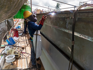 The welder is welding a steel structure work with process Flux Cored Arc Welding(FCAW) and dressed...