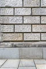 Abstract architectural background with gray wall made of stone blocks, plinth and paving