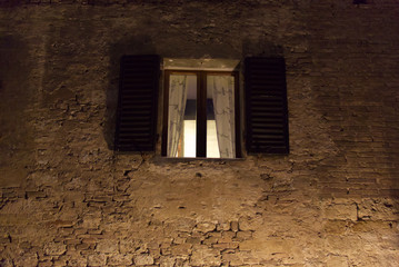 Window of a palace at night in the city of San Gimignano in Tuscany
