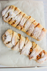 Apple strudel in the form of a pigtail from puff pastry