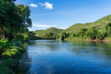 Fototapeta na wymiar The clear stream flowing in the river reflects the blue sky. Flows through the mountains at the Kwai Yai River, Kanchanaburi, Thailand.