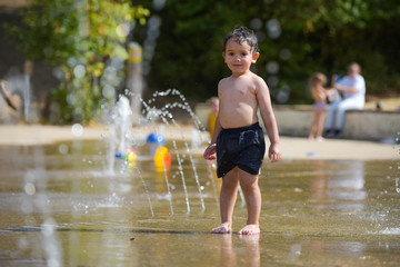 young boy playing at the paddling pool