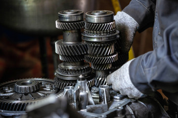 A worker repairs the car's transmission