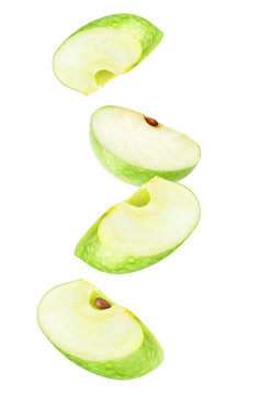 Isolated apple wedges in the air. Four falling pieces of green apple fruit isolated on white background