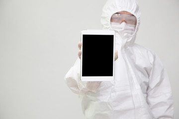 Asian nurse or doctor in Personal Protective Equipment or PPE suit uniform holding tablet isolated on white background