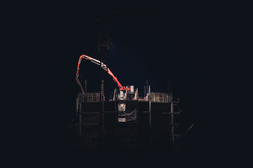 construction crane on top of a building. night construction.