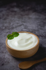 Plain Yogurt in wooden bowl on table