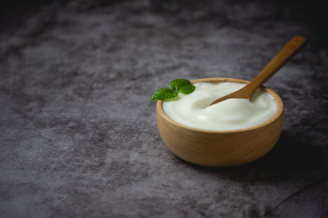 Plain Yogurt in wooden bowl on table