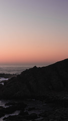 Plakat Atardecer en montaña situada en el borde costero de playas de Punta Tralca,un cielo despejado con hermosos tonos.