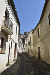 Obraz premium A narrow street among the old houses of Altomonte, a rural village in the Calabria region.