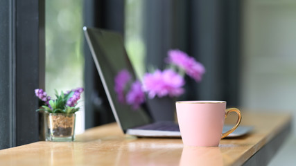 Pink coffee cup on working desk.