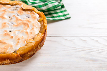 Pear pie with cream, homemade pastries on the table with a green napkin.