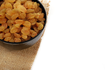 Bowl with dried golden raisins isolated on white. Dried Grapes.