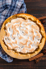 Pear pie with cream, homemade pastries on the wooden table, with spices. Copy space.