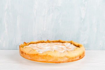 Pear pie with cream, homemade delicious pastries, dessert for breakfast, on a white table. Copy space.