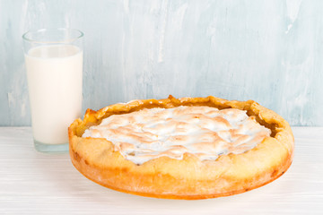 Pear pie with cream, homemade delicious pastries and milk, dessert for breakfast, on a white table.