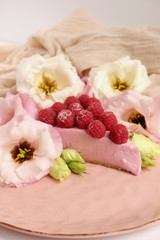 Raspberry cheesecake with berries and fresh flowers on pink plate food photo, sweet cake food photo art, kitchen, menu and restaurant photoshoot