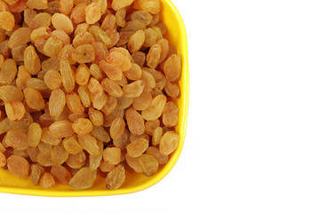 Bowl with dried golden raisins isolated on white. Dried Grapes.