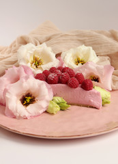 Raspberry cheesecake with berries and fresh flowers on pink plate food photo, sweet cake food photo art, kitchen, menu and restaurant photoshoot