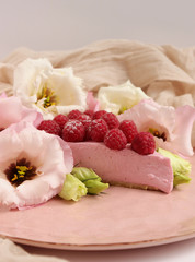 Obraz na płótnie Canvas Raspberry cheesecake with berries and fresh flowers on pink plate food photo, sweet cake food photo art, kitchen, menu and restaurant photoshoot