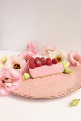 Raspberry cheesecake with berries and fresh flowers on pink plate food photo, sweet cake food photo art, kitchen, menu and restaurant photoshoot