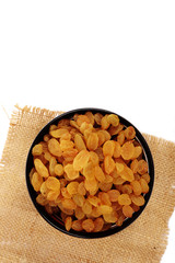 Bowl with dried golden raisins isolated on white. Dried Grapes.