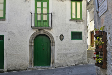 Fototapeta na wymiar A narrow street among the old houses of Laino Borgo, a rural village in the Calabria region.