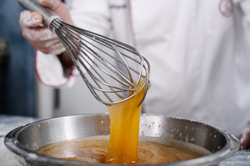 close-up of a baker pouring oil to make cupcakes