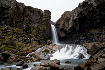 Perfect landscape of Folaldafoss waterfall with rock path over water in the east of Iceland island