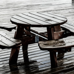 Round Picnic Table And Chairs Outside In The Rain