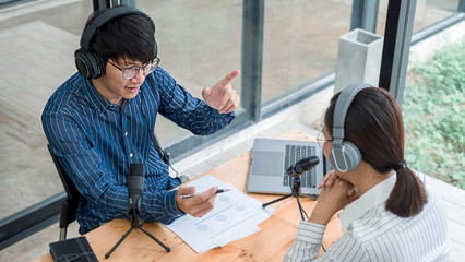 Young business people recording a podcast in a studio