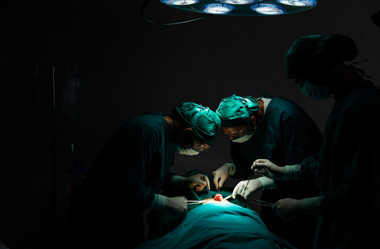 Surgery team operating in  in the operating theatre. Medical team performing surgical operation in operating room. Group of surgeons in hospital operation theater.