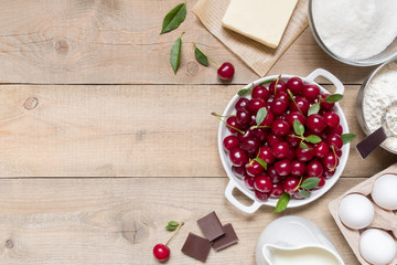 Top view raw ingredients for cooking cherry pie on wooden background with copy space. Bakery background.