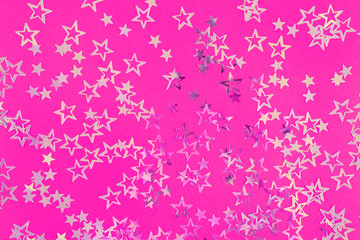Golden sparkling stars on neon pink background, festive or holiday concept. Beautiful abstract backdrop for your blog or project