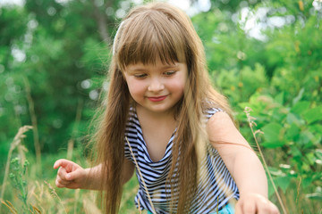 A little girl makes her way through the grass