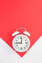 White alarm clock on the bicolor surface. Top view. Copy space. Location vertical.