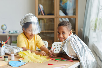 Portrait of two African-American boys making space suits while enjoying art and craft lesson in...