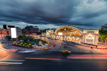 Facade antique Hua Lamphong railway station illuminated with car traffic on the roundabout road in...