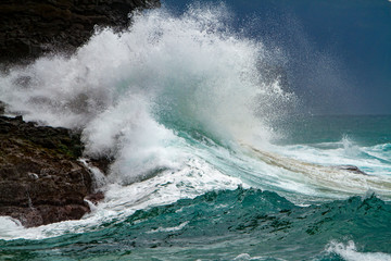 Fototapeta premium Waves crashing on the headlands on the north shore of Kauai, Hawaii.