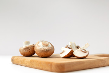 fresh beige cultured mushrooms on a cutting Board on a white background. concept of the harvest season.
