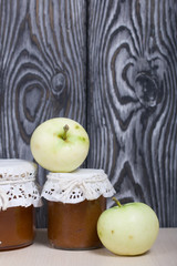 Apple jam in jars. Apples nearby. Fruit harvest.
