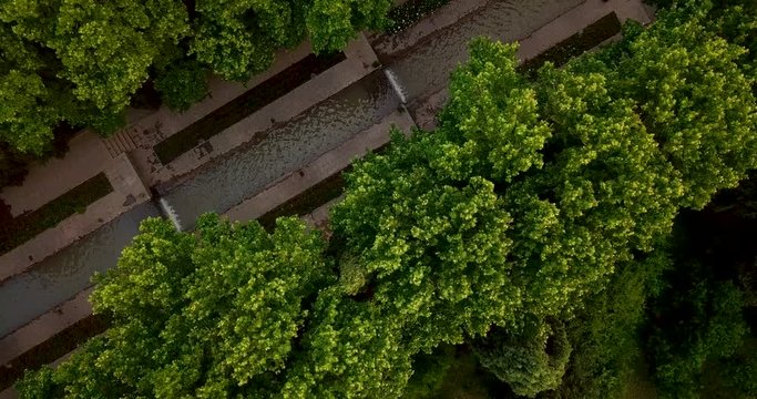 Aerial visit the Persian Garden water stream waterfall surrounded by tall green trees in the yard in Mahan Kerman Iran
