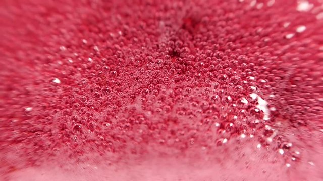 Raspberry syrup. Pink background with bubbling bubbles and raspberries.