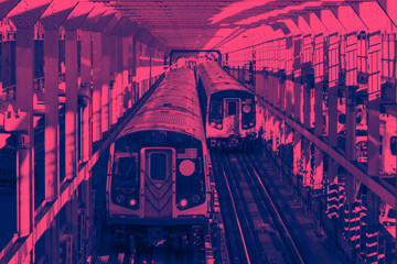 Subway cars crossing the Williamsburg Bridge from Brooklyn to Manhattan in New York City with pink and blue colors