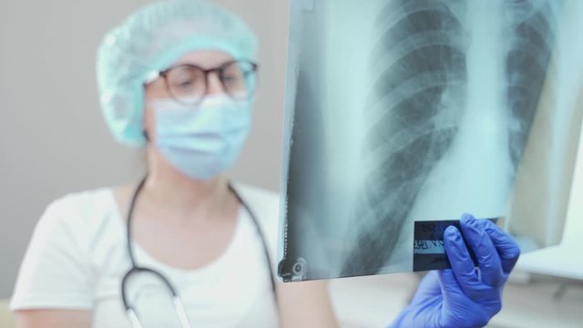 female doctor therapist examines the fluorography. woman pulmonologist looking at a picture lungs. Diagnosis clinic of a patient with inflammation. tomography cabinet. Hospital or polyclinic x-ray