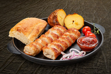 Lula kebab with grilled potatoes, matnakash and red sauce. Served in a cast iron pan