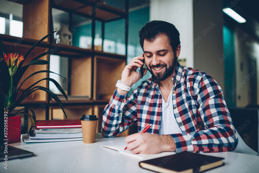 Aufkleber smiling hipster guy communicated via smartphone while connected to 4g internet and notes to textbook
